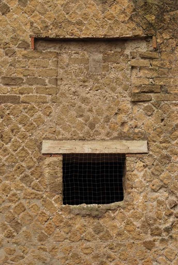 A large brown brick building next to a stone wall
Description generated with high confidence